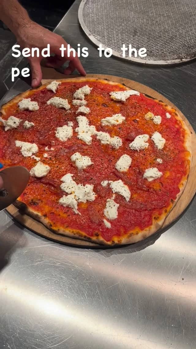 Pizza rossa with salami piccante and mozzarella di bufala being cut